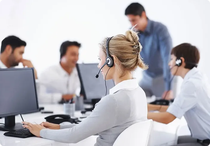 Mitarbeitende einer Taxi-Telefonzentrale mit Headsets an ihren Arbeitsplätzen