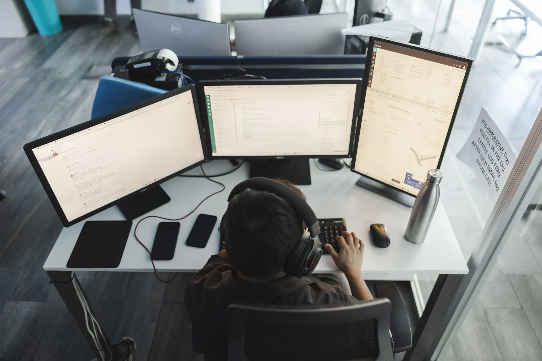 A dispatch workstation with three screens and a headset