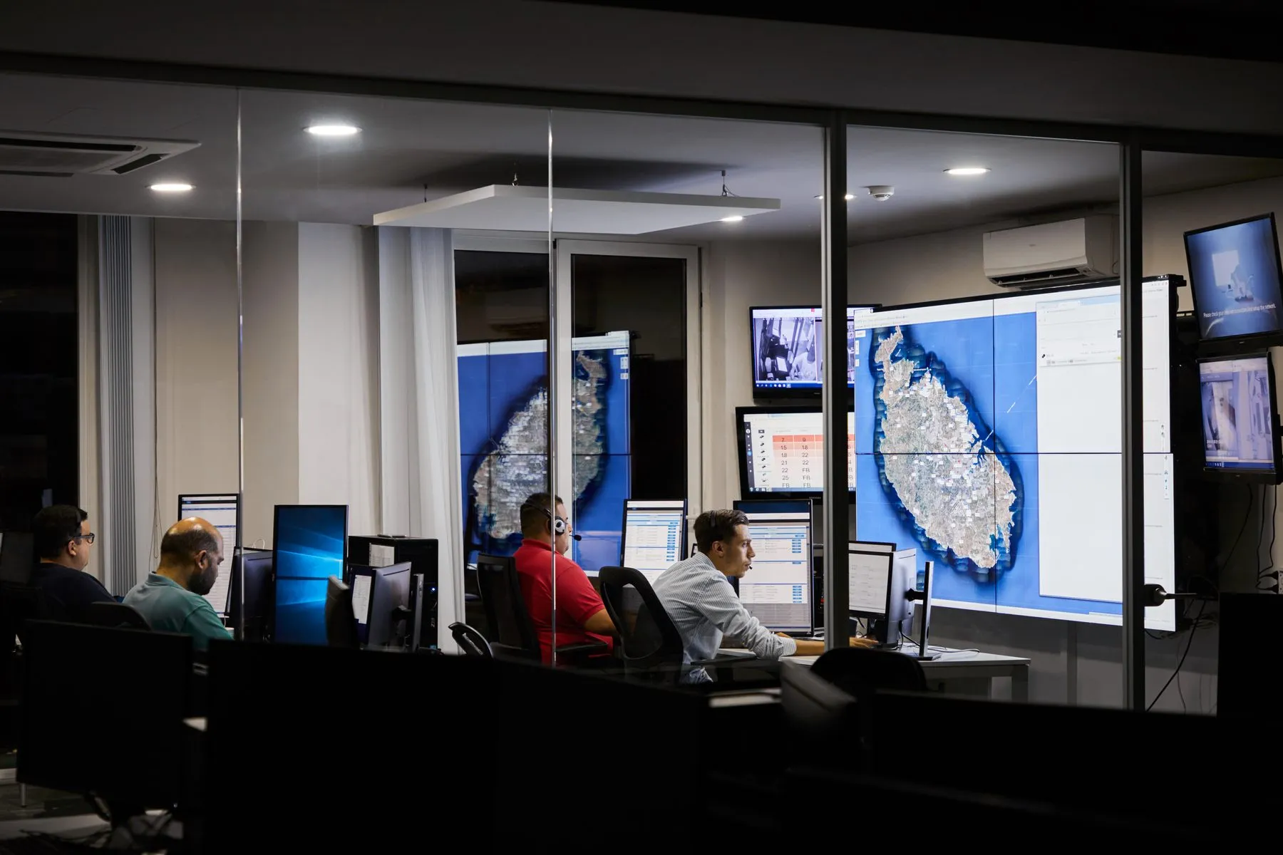 The eCabs dispatch room at night, with live maps of Malta on the video wall