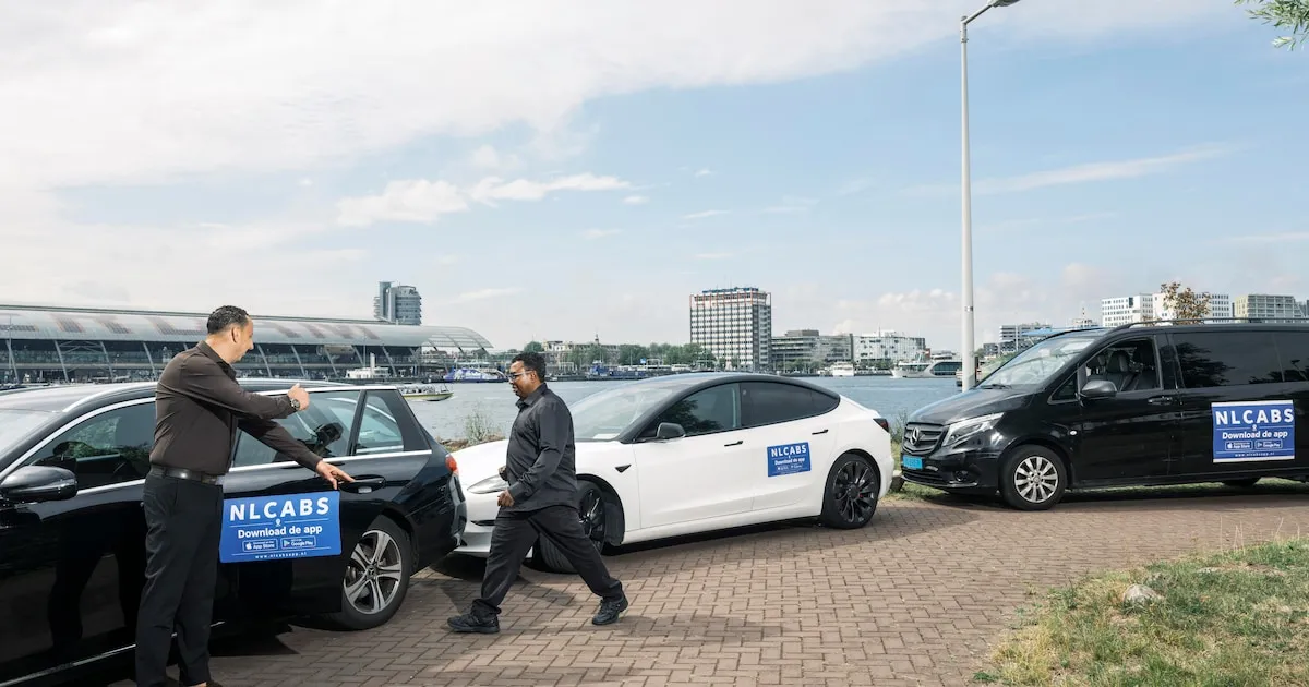 NLCabs drivers with their branded cars by the IJ waterfront in Amsterdam, near Centraal Station