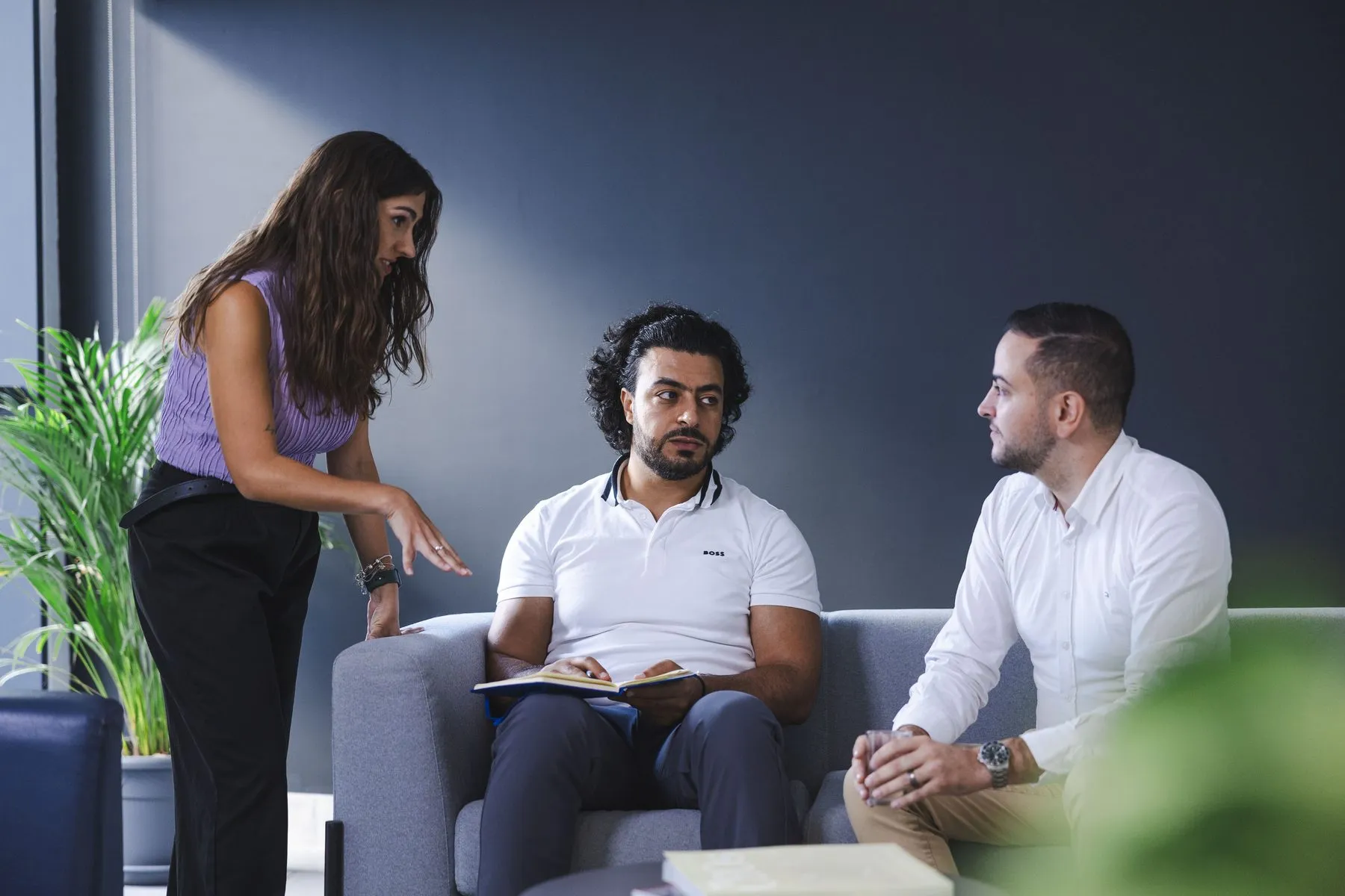 Colleagues discussing a project in the office lounge